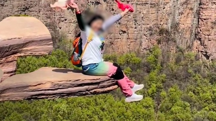 悬崖试胆石现裂缝游客仍坐边缘打卡